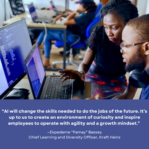 Two coworkers sit side by side in a computer lab, focused on a coding project displayed on dual monitors. The woman points to the screen, actively discussing with the man beside her. Other individuals work at computers in the background. A quote overlay reads: "AI will change the skills needed to do the jobs of the future. It’s up to us to create an environment of curiosity and inspire employees to operate with agility and a growth mindset." —Ekpedeme “Pamay” Bassey, Chief Learning and Diversity Officer, Kraft Heinz.
